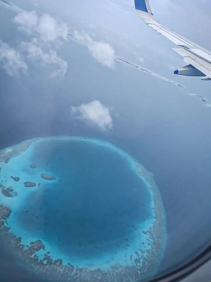 A stunning view of a circular atoll from the air as we approach the Maldives. These unique coral formations create the calm lagoons and rich channel dives that make the area so special.
