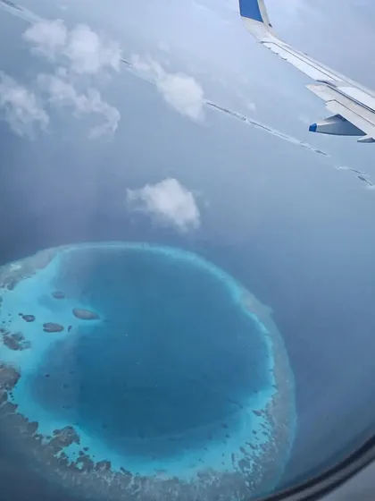 A stunning view of a circular atoll from the air as we approach the Maldives. These unique coral formations create the calm lagoons and rich channel dives that make the area so special.
