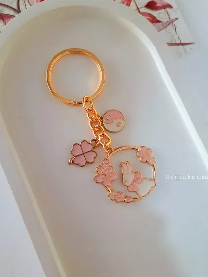 Starting the new year with pink magic. This custom keychain features a bunny in a floral wreath, a lucky clover, and a yin-yang charm, all in a beautiful pink enamel.