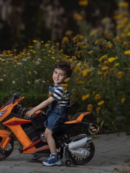 Another wonderful shot from our outdoor bike ride session. The warm sunlight filtering through the flowers creates a magical atmosphere as this little adventurer enjoys his ride.