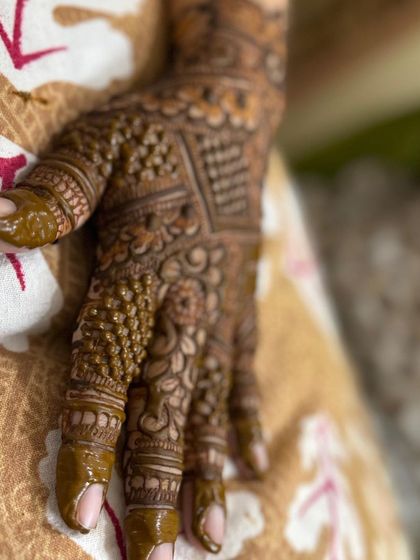 A close-up of a detailed Indian design on the back of the hand.