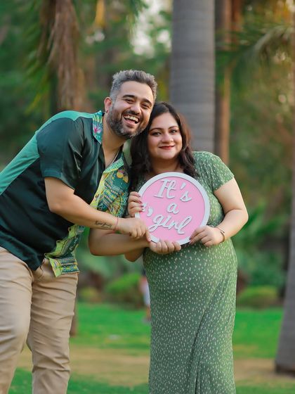 A happy and bright gender reveal photo. The couple's excitement is palpable as they announce they are expecting a girl.