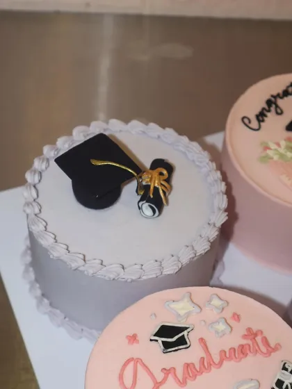 A simple and elegant graduation bento cake, topped with a fondant graduation cap and diploma. It’s a classic design for a timeless achievement.