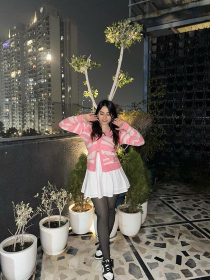 A fun, expressive pose in the pink cardigan. This shows my personality and makes the content more engaging.