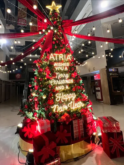 For the Atria Mall, I designed a festive installation that was all about big impact. This towering Christmas tree became the centerpiece, featuring custom neon signage with holiday wishes, classic red and gold ornaments, and dramatic overhead lighting to draw in shoppers and create a magical atmosphere.