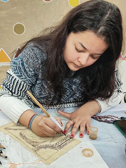Another student engrossed in the detailed line work of Kalamkari art, learning the patience and precision this traditional form requires.