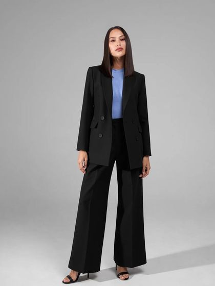 A classic black power suit is a wardrobe essential. This one features a double-breasted blazer and dramatic wide-leg trousers for a timeless and commanding look.