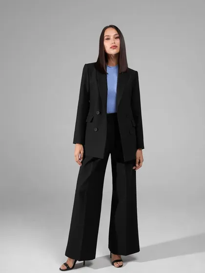 A classic black power suit is a wardrobe essential. This one features a double-breasted blazer and dramatic wide-leg trousers for a timeless and commanding look.