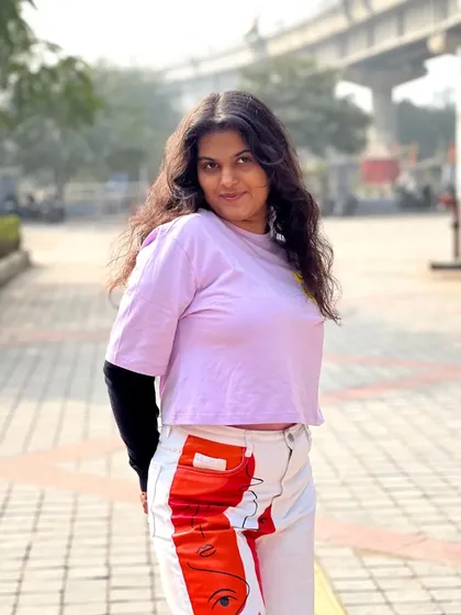 A portrait shot showing the casual and cool vibe of the abstract street style look. The simple hair and makeup keep the focus on the creative outfit.