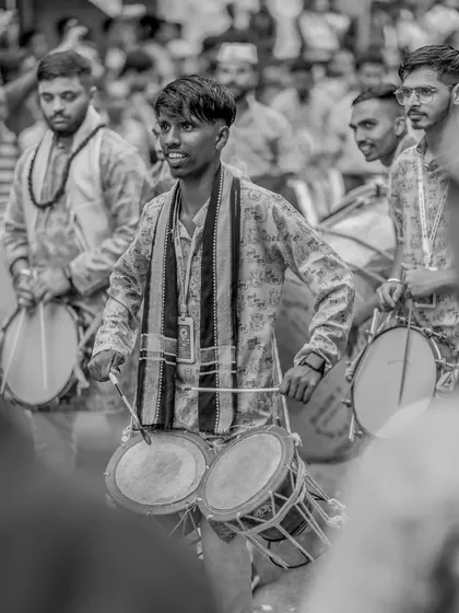 A black and white shot of a smiling tasha player, capturing a candid moment of enjoyment.
