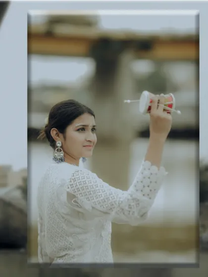 A portrait of a devotee holding a damru, symbolizing the cosmic rhythm of Shiva, with a soft, contemplative expression.