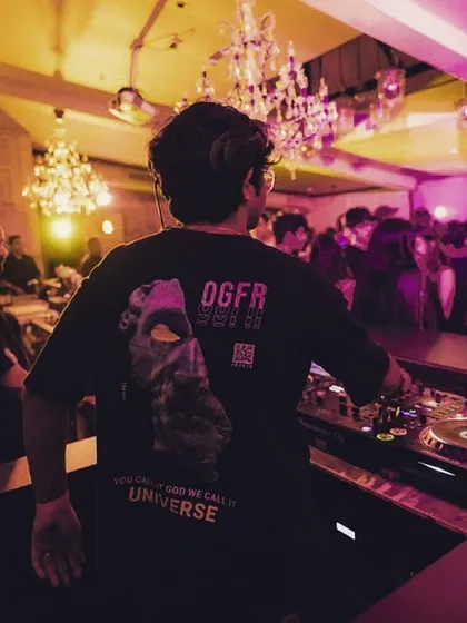A shot from behind, showing off my shirt and the elegant chandeliers of the venue. Even in a high-energy party, the atmosphere matters.