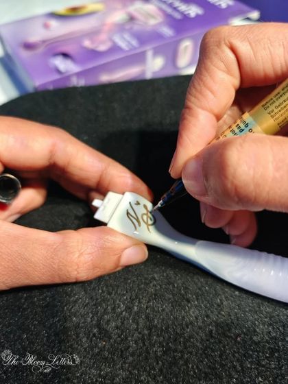 A close-up of the calligraphy process on a Gillette razor. I use specialized pens that allow me to write smoothly on unique surfaces like this, ensuring the personalization is both beautiful and durable.
