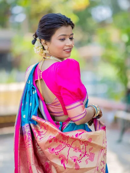 A side profile showcasing the delicate floral accessory in this soft textured bun. It's a simple touch that adds a lot of charm to the overall traditional Maharashtrian look.