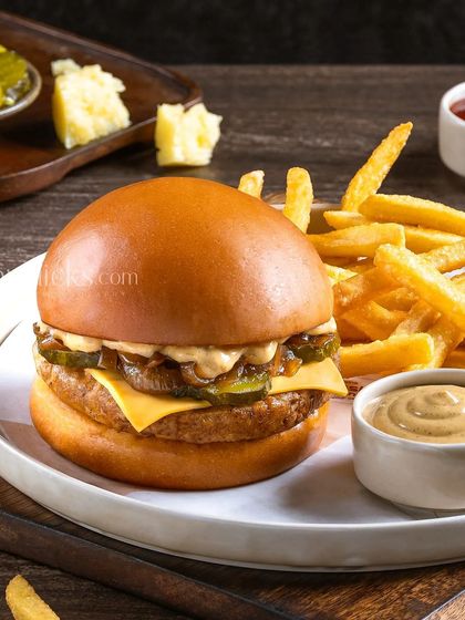 A classic veggie burger with cheese, pickles, and caramelized onions, served with fries and mustard.