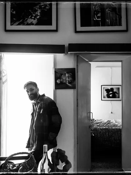 From my 'Doorways' series, this is Raghav. The reflection in the glass and the layers of the room create a complex and introspective portrait.