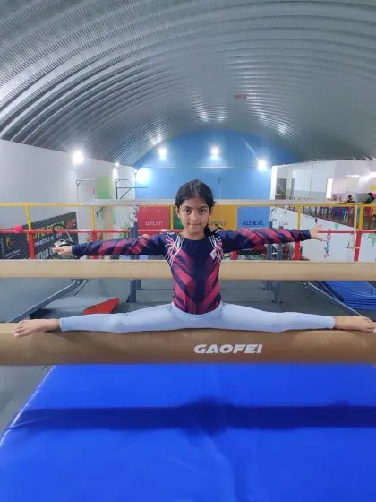 Balance, focus, and a smile. One of our intermediate gymnasts mastering the split on the balance beam, a fundamental skill in artistic gymnastics that builds incredible confidence.