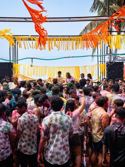 A wide shot of the crowd dancing at our Goa Holi party. I manage large-scale outdoor events, ensuring the space is well-organized with great sound and vibrant decor.