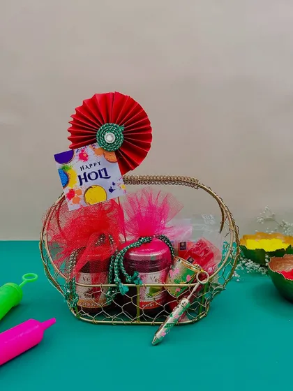 This small gold wire basket is perfect for a personal Holi gift. It contains jars of thandai mix or snacks, along with a pichkari and a packet of gulal.