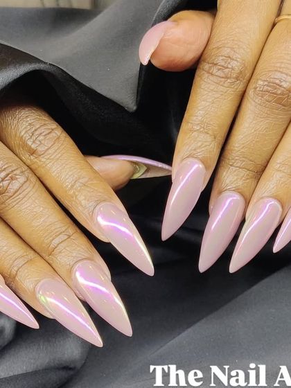A stunning set of extra-long stiletto nails with a pearlescent, iridescent pink chrome finish that catches the light beautifully.