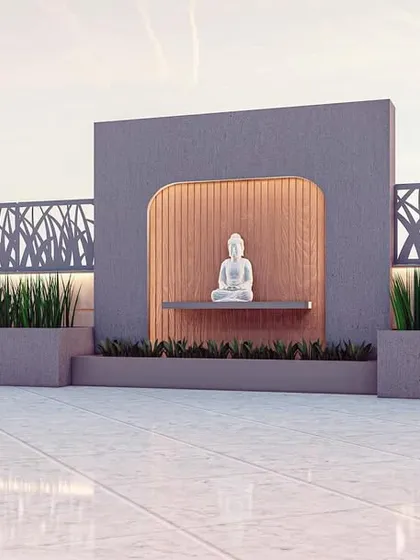 A close-up of the zen-inspired water feature and meditation spot from our Kirtinagar terrace design. The niche with a Buddha statue is highlighted by warm, recessed lighting and flanked by planters, creating a peaceful corner for relaxation.