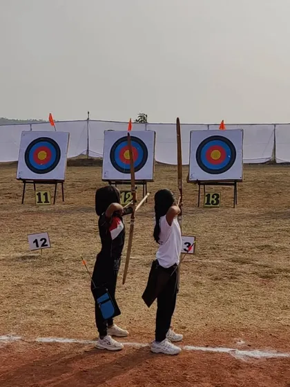 Young archers at the state competition, demonstrating their shooting stance with traditional wooden bows.