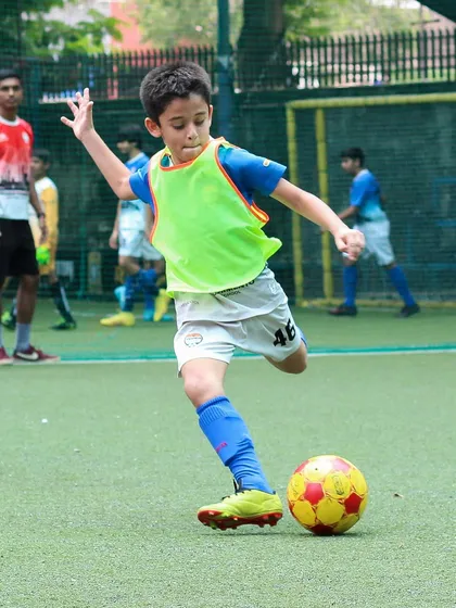 A young player from our youth program demonstrates perfect form, striking the ball with power and precision during a training session. We focus on developing strong technical fundamentals from an early age.