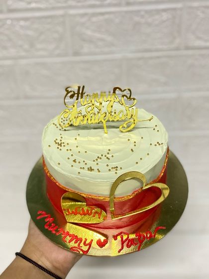 A hand-held view of the anniversary cake, showing its elegant design.