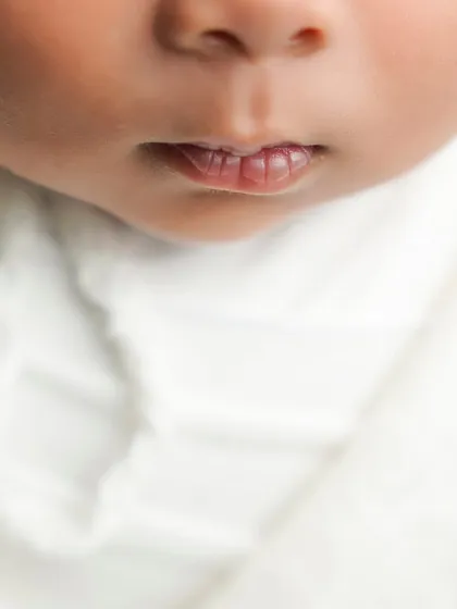 A macro shot focusing on the tiny, perfect shape of a newborn's lips. This is part of my fine art approach to newborn photography, celebrating every small detail.