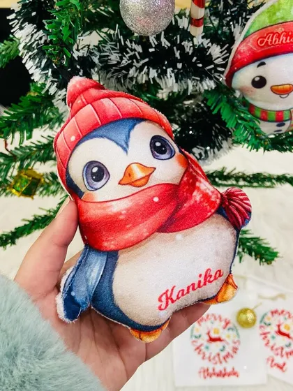 Holding our adorable personalised penguin plush ornament. These are soft, cuddly, and kid-friendly.