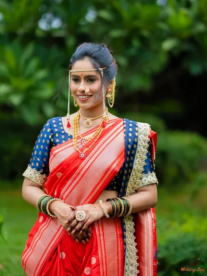 A full-length view of this radiant bride in her red Nauvari. The drape is styled to be comfortable and photogenic, allowing her to smile with genuine happiness.