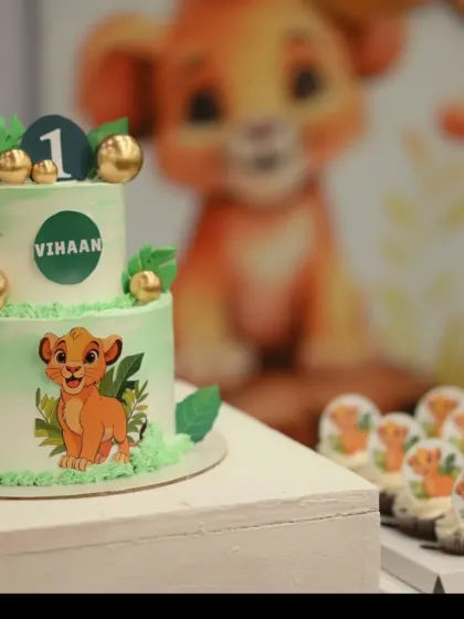 This two-tier Simba cake was for a first birthday party. I used a soft green and white color palette and decorated it with edible leaves, gold accents, and of course, a cute Simba graphic.