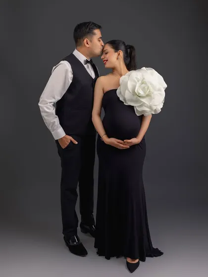 A beautiful, tender moment with a forehead kiss, highlighting the couple's bond in this elegant, formal maternity shoot.