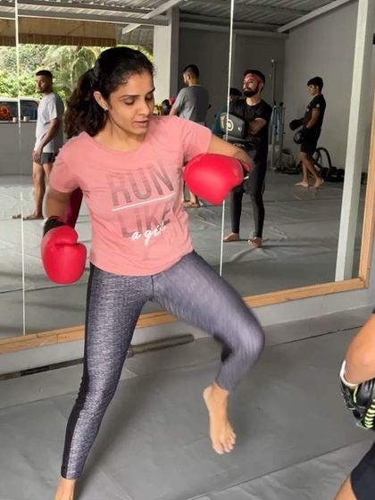 A member working on her boxing combos during a busy class.