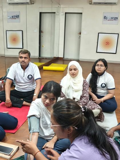 An instructor provides guidance during a practical blood pressure measurement session, ensuring our students learn the correct procedures.