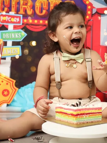 Welcome to the greatest show on earth, starring this adorable two-year-old. A cake smash during a circus-themed photoshoot is the perfect way to capture pure, uninhibited joy and a little bit of happy mess.