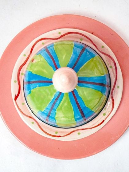 A top-down, minimalist shot of the butter dish on a pink plate. This clean composition is perfect for an e-commerce product listing.