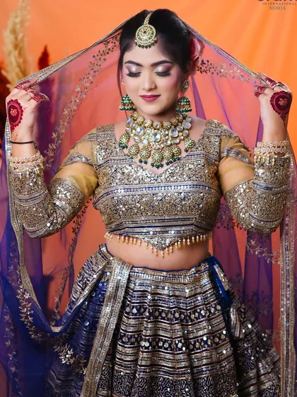 This pose with the veil shows the full bridal look, including the heavy embroidery on the lehenga and the elegant drape.