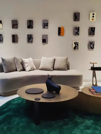 A wall installation of twenty-four small, individual mixed-media panels. Each panel is a unique abstract composition, creating a playful and sophisticated gallery wall in this Hyderabad residence.