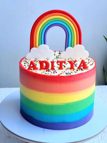 A vibrant rainbow cake with buttercream stripes. I show you how to create smooth, blended stripes and a perfect fondant rainbow topper.