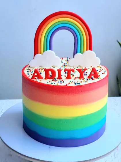 A vibrant rainbow cake with buttercream stripes. I show you how to create smooth, blended stripes and a perfect fondant rainbow topper.