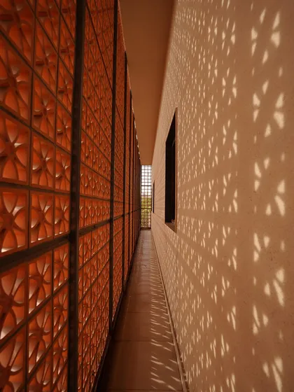 A key feature of The Lantern House is the perforated terracotta jaali that caps the home. It acts as a climate tool by blocking harsh sun, serves as a privacy screen, and transforms the house into a glowing lantern at night.