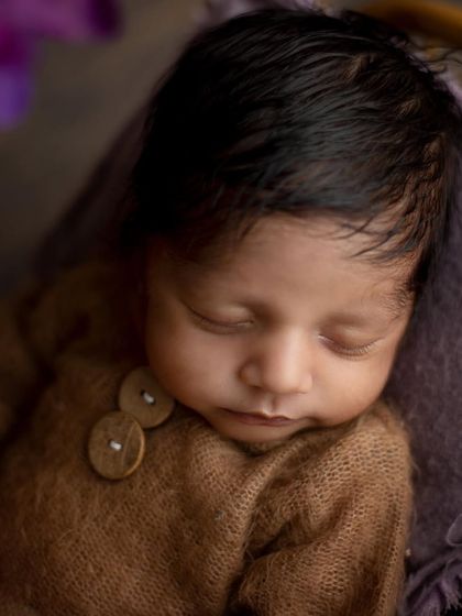 A close-up of this handsome little man. Look at that full head of hair! The soft textures of the knit outfit and blanket add to the cozy feeling of the photo.