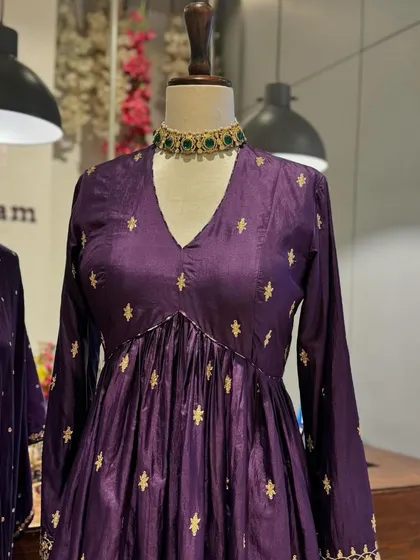 Royal purple is always a statement. This anarkali is adorned with delicate gold buttis, offering a look of regal elegance.