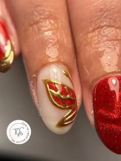 A macro shot of a hand-painted red and gold leaf design. This is a perfect accent for a bold, festive red manicure.