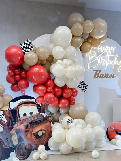 A close-up of the modern Cars party decor, showing the balloon arrangements and checkered flag details.