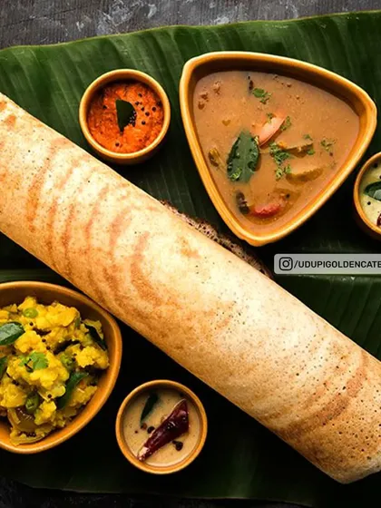 Our signature Masala Dosa, served authentically on a banana leaf. This complete platter features a perfectly crisp dosa filled with spiced potato masala, accompanied by fresh coconut chutney, tangy tomato chutney, and our flavorful vegetable sambar. It's a centerpiece for any breakfast event.