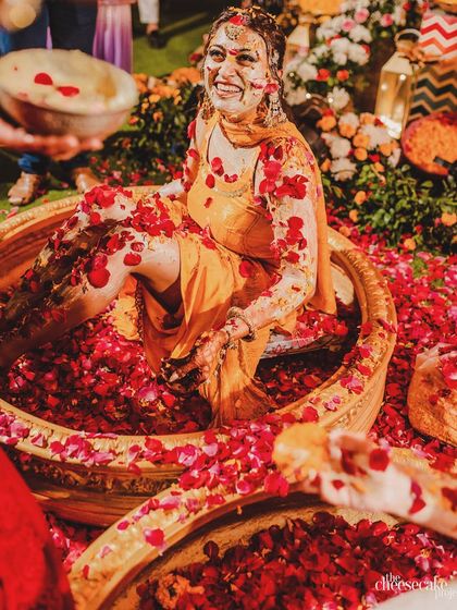 A joyous 'phoolon ki haldi' moment. We love creating setups with tubs of fresh rose petals, turning the haldi ceremony into a truly immersive and fragrant experience.