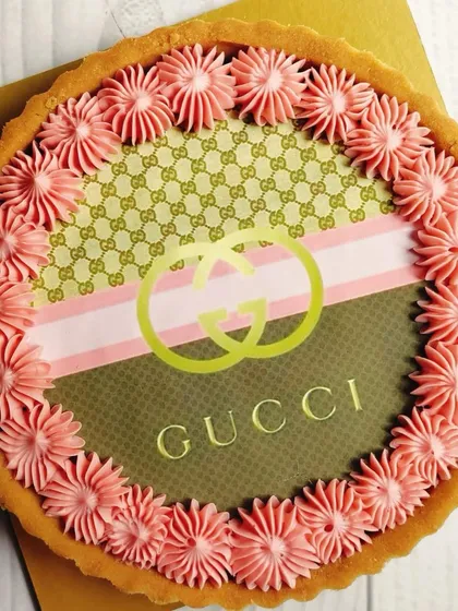 A detailed shot of the Gucci-inspired tart, highlighting the precision of the edible print and the soft texture of the surrounding buttercream. It's a taste of luxury in every sense.