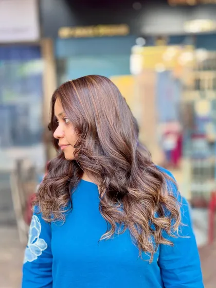 A soft blonde hair color achieved without bleach. This look adds gentle, warm highlights to a dark base for a subtle and natural-looking enhancement.